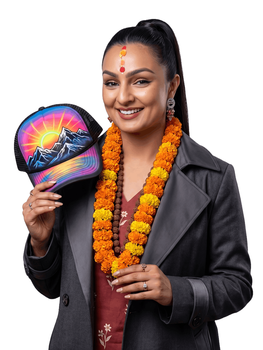 Aaditi Pokharel holding a hand-painted airbrush hat from Himalayan Exports — custom Nepal apparel and wearable art